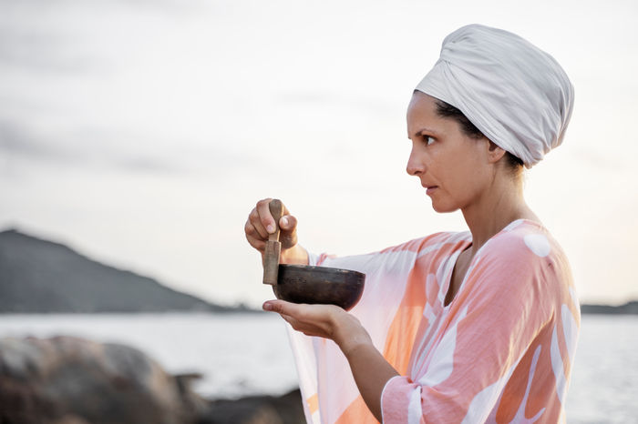 A woman with a singing bowl in a moment of stillness